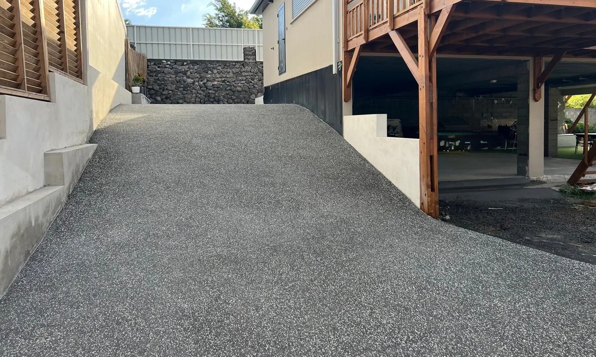 Rampe d'accès en béton désactivé à granulats blancs devant une villa à La Réunion