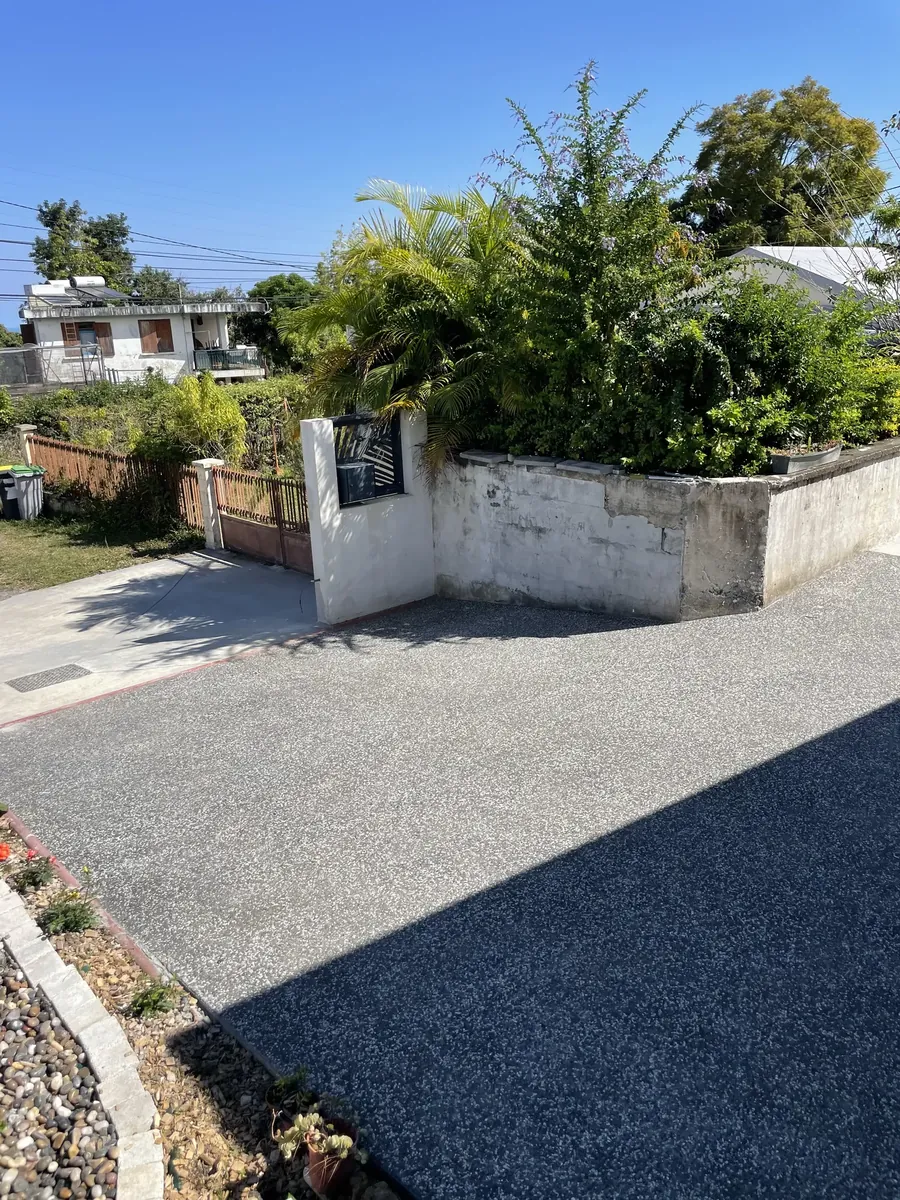 Allée courbe en béton désactivé le long d'un muret