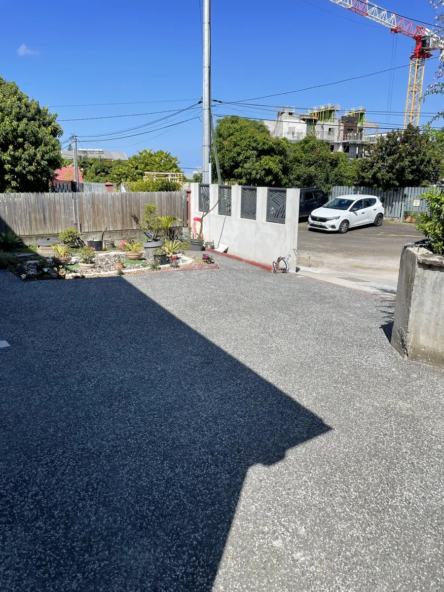 Grande cour en béton désactivé devant un portail à La Réunion