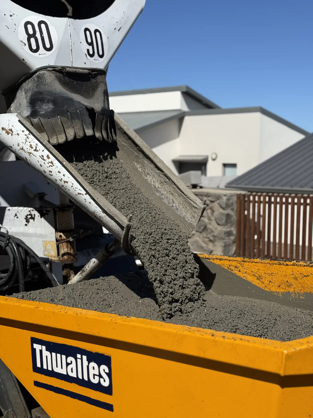Béton frais déchargé de la toupie dans le dumper de chantier