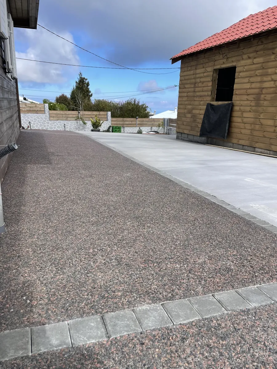 Béton désactivé rosé bordé d'une dalle balayée claire