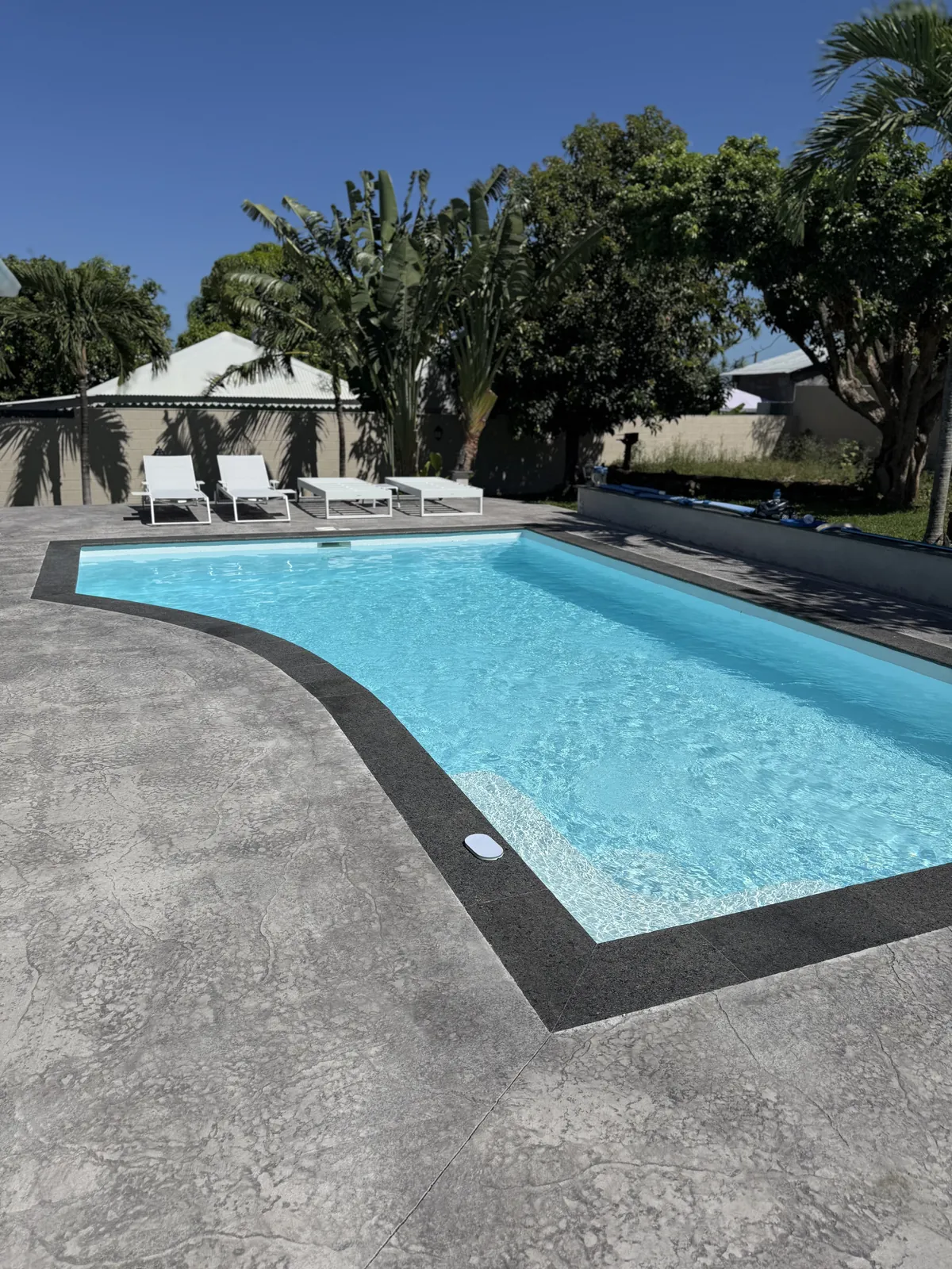 Après : la plage refaite en béton imprimé gris, margelles anthracite