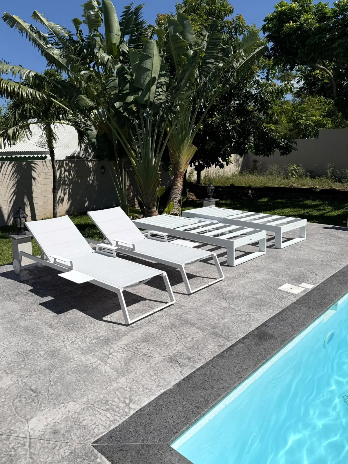 Plage de piscine en béton imprimé gris et transats, à La Réunion