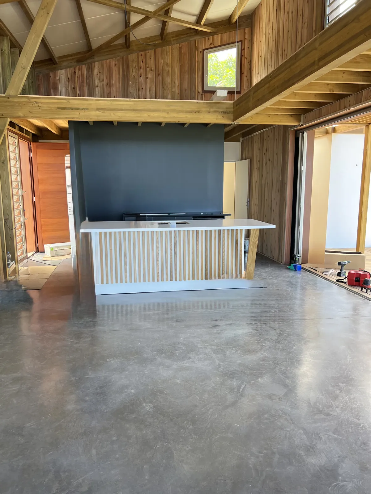 Sol intérieur en béton lissé sous charpente bois à La Réunion