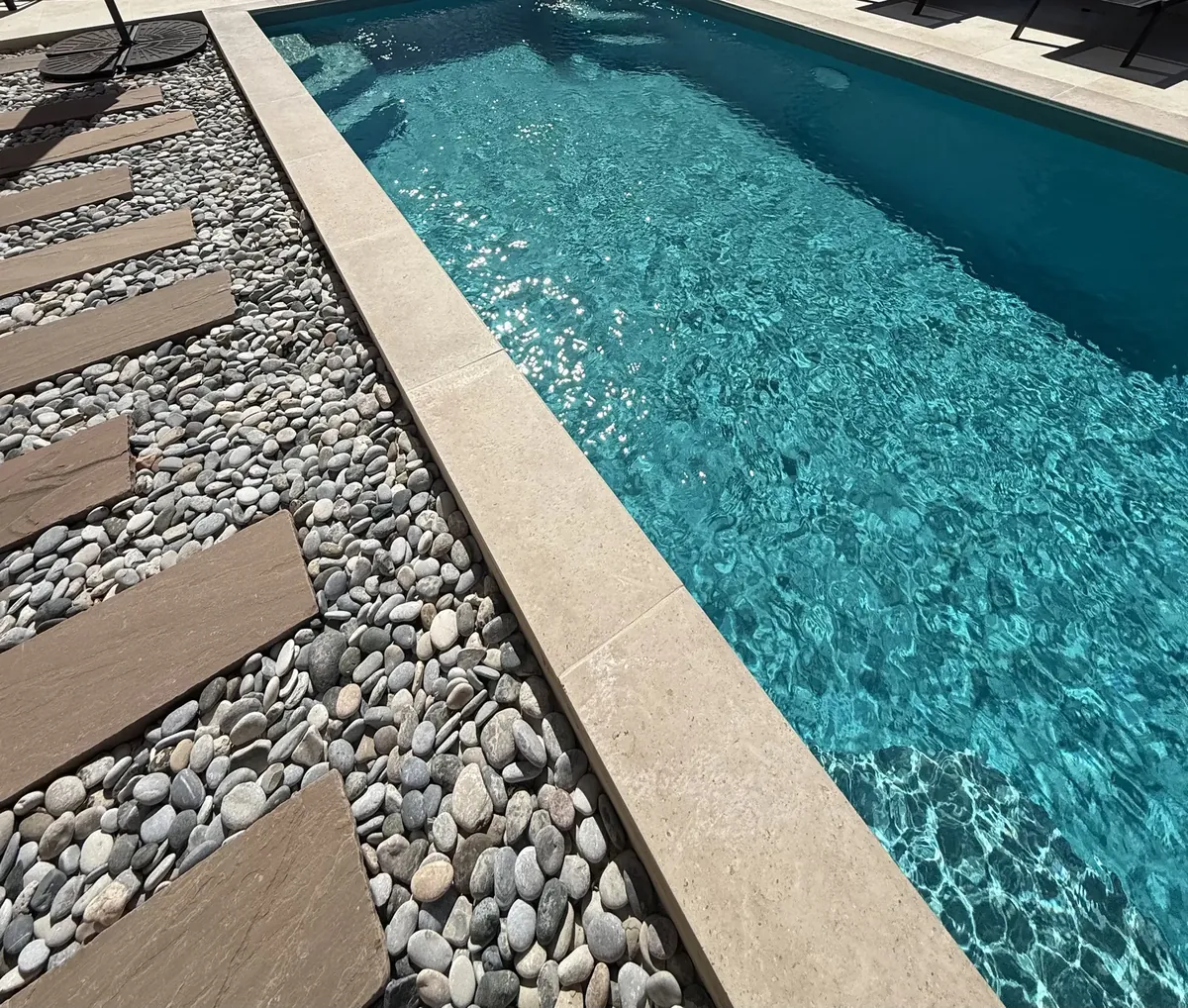 Bordure de piscine claire avec pas japonais et lit de galets